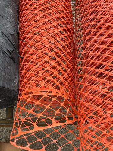Multiple Rolls Of Orange Construction Netting Barrier